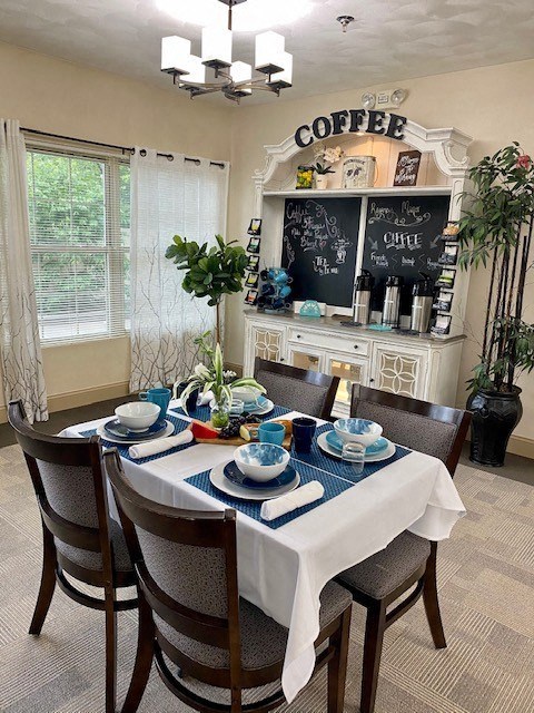 a dining room table with blue and white plates and chairs
