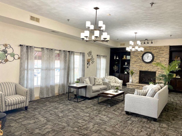 a living room with couches and chairs and a clock on the wall