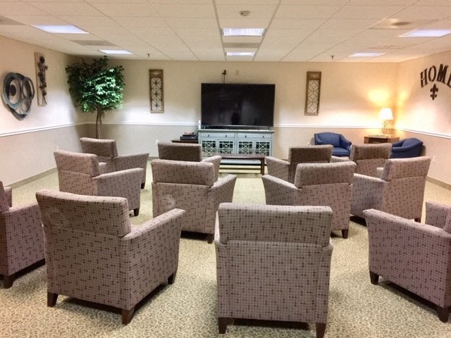 the waiting room of a hospital with chairs and a tv