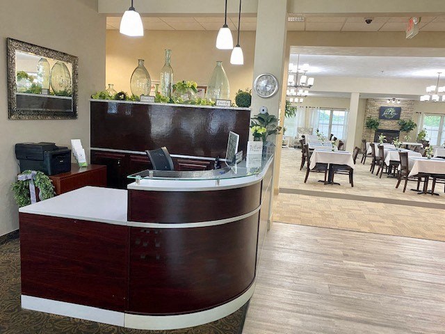 a hotel lobby with a reception desk and tables
