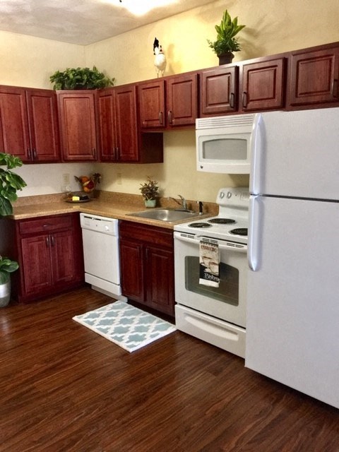 a kitchen with white appliances and wooden cabinets