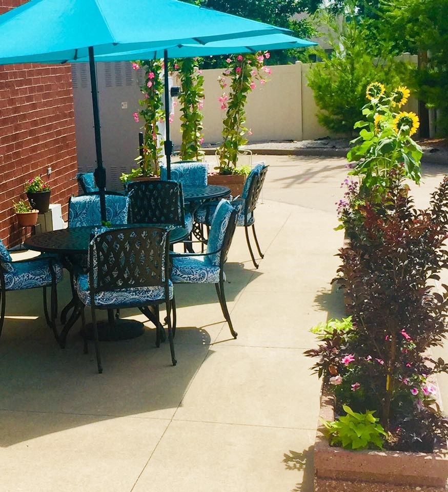 a patio with a table and chairs under an umbrella