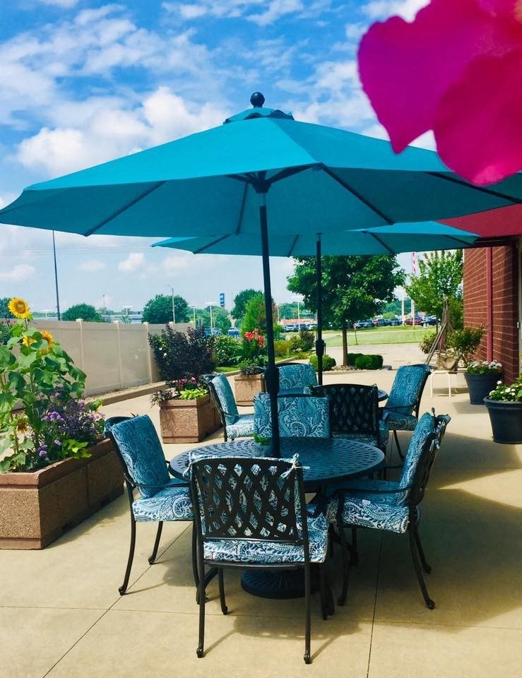 a patio with a table and chairs under an umbrella