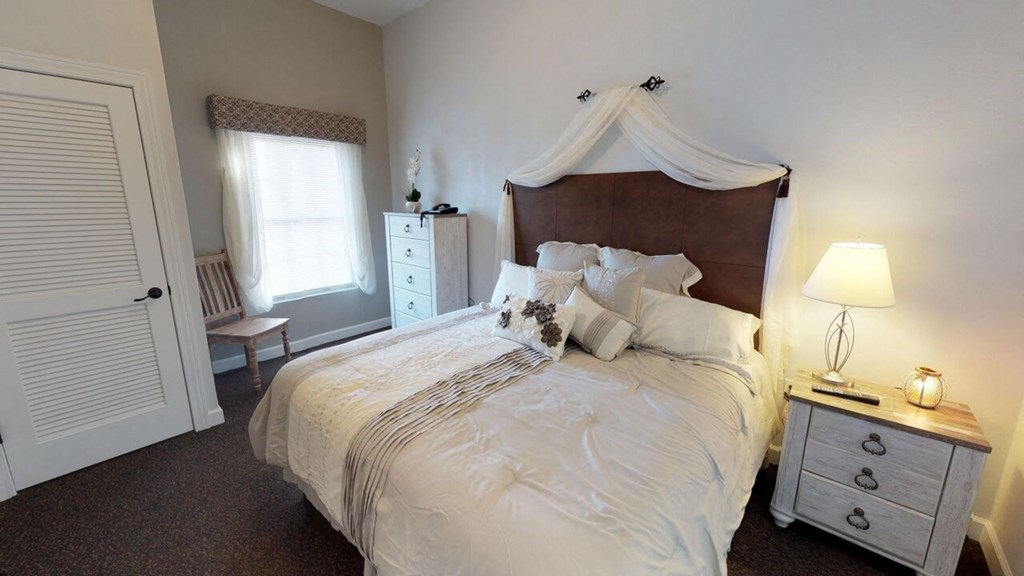 a bedroom with a bed and a dresser and a window