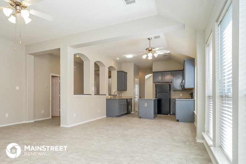 an open kitchen and living room with a ceiling fan