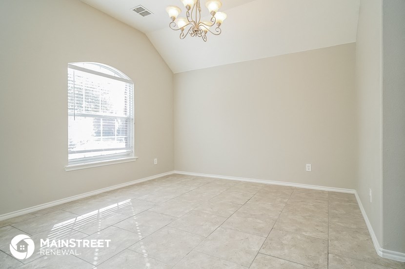 the spacious living room with a large window and tiled floors