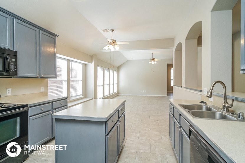 a kitchen with stainless steel appliances and white counter tops