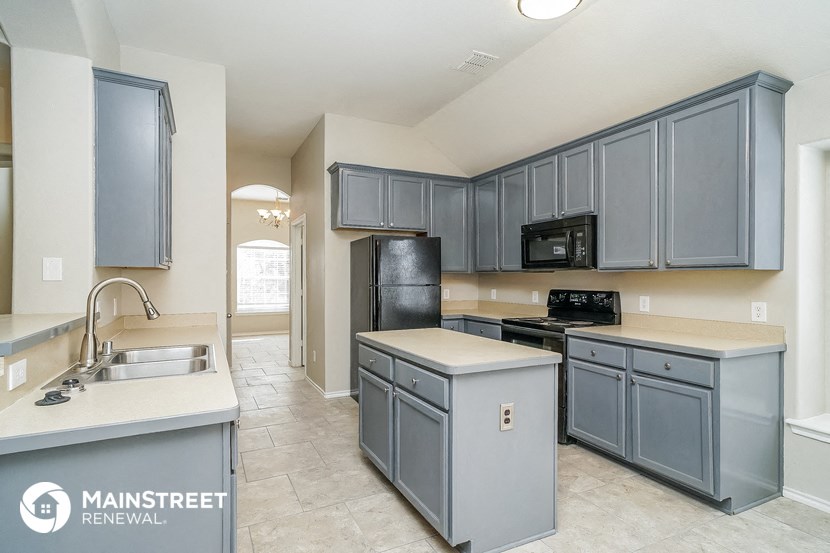 a kitchen with blue cabinets and a black stove and a sink