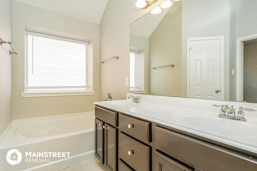 a bathroom with a sink and a tub and a mirror