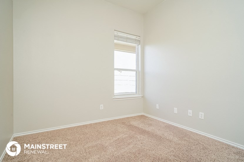 an empty room with a window and carpet