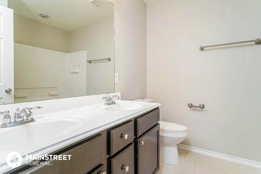 a white bathroom with two sinks and a toilet