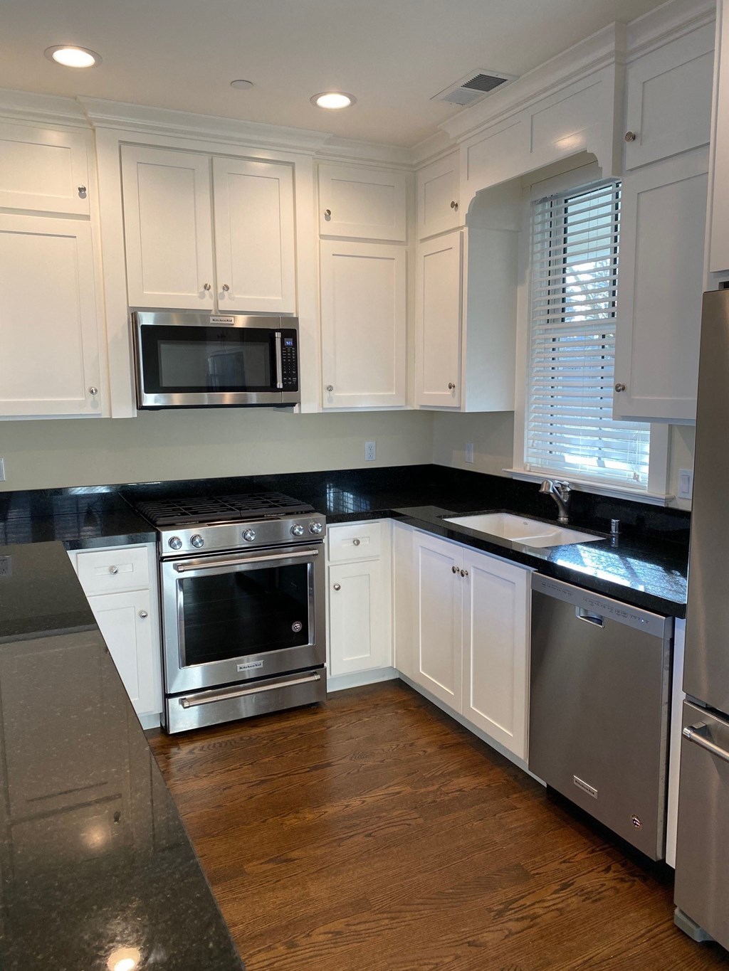 a kitchen with white cabinets and stainless steel appliances