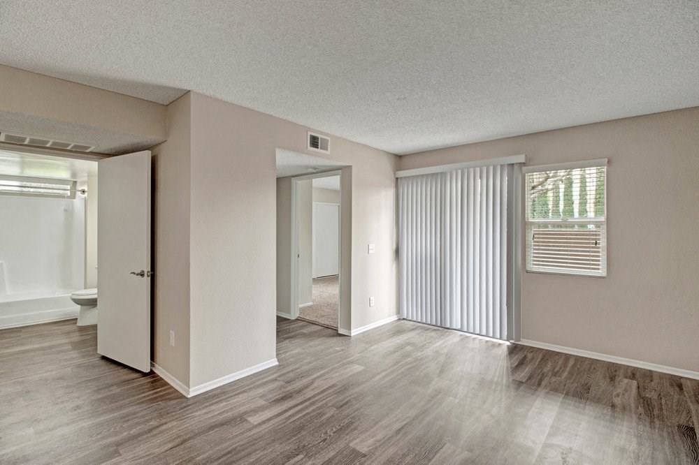 the spacious living room and dining room of an apartment
