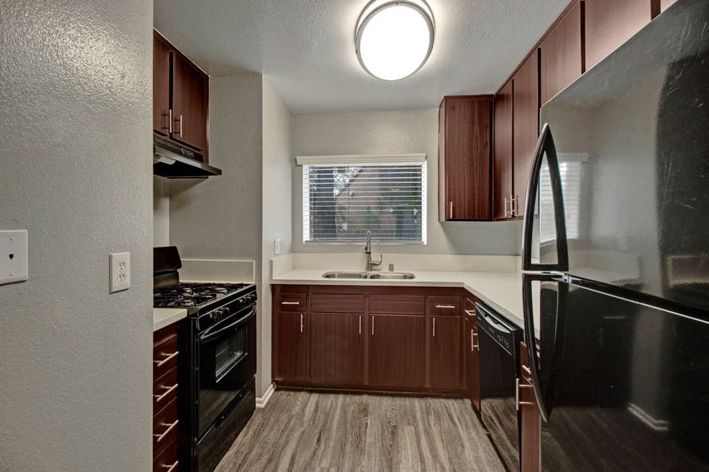 a kitchen with black appliances and wooden cabinets