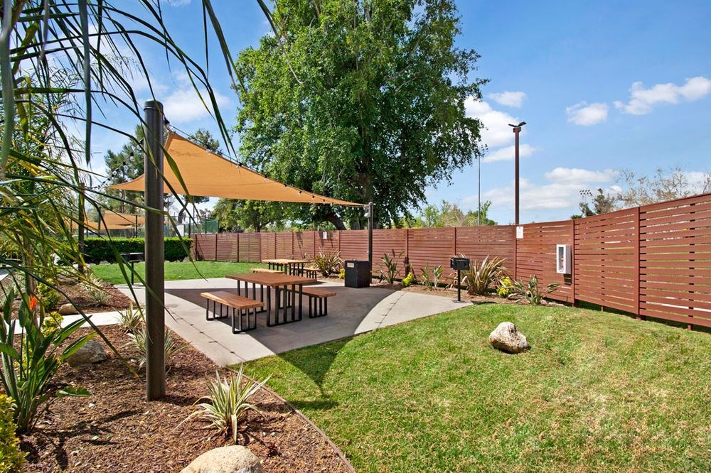 a patio with a picnic table and a fence