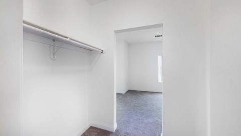 A white room with a grey carpet and a white wall with a white door.