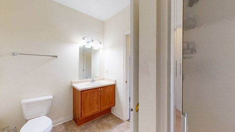 A bathroom with a toilet, sink, and medicine cabinet.