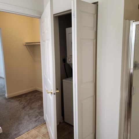 A white door is open to a small kitchen.