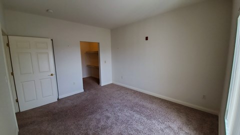 A room with a carpeted floor and a white door.