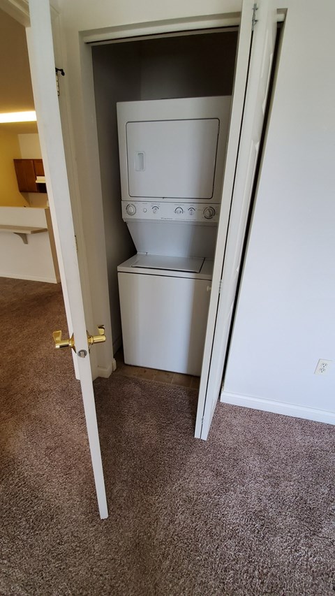 A white oven and microwave in a small room.