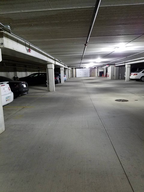 A parking garage with a white car parked on the left side.