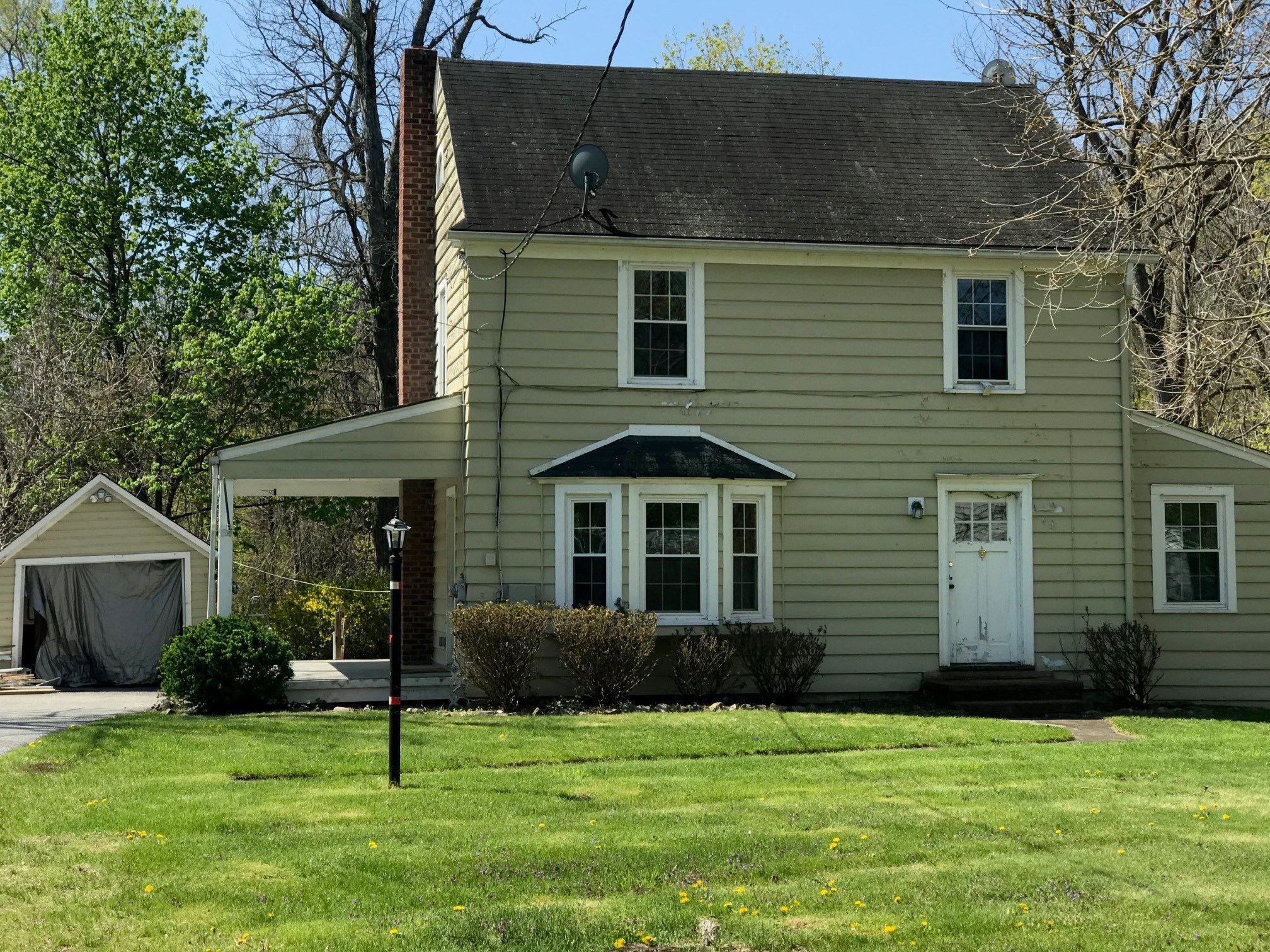 a yellow house with a lawn and a white door
