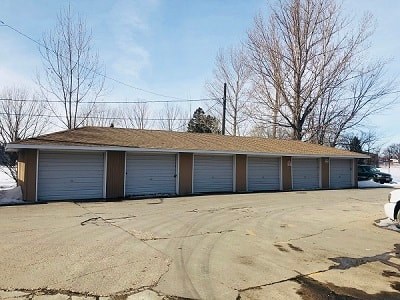 A large building with a brown roof and four garage doors.