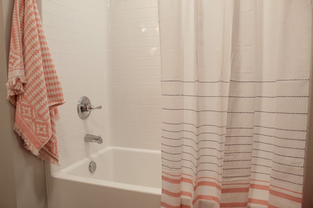 a bathroom with a shower curtain and a tub
