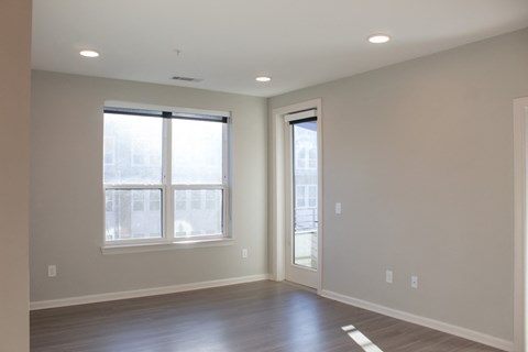 a living room with a large window and wooden floors