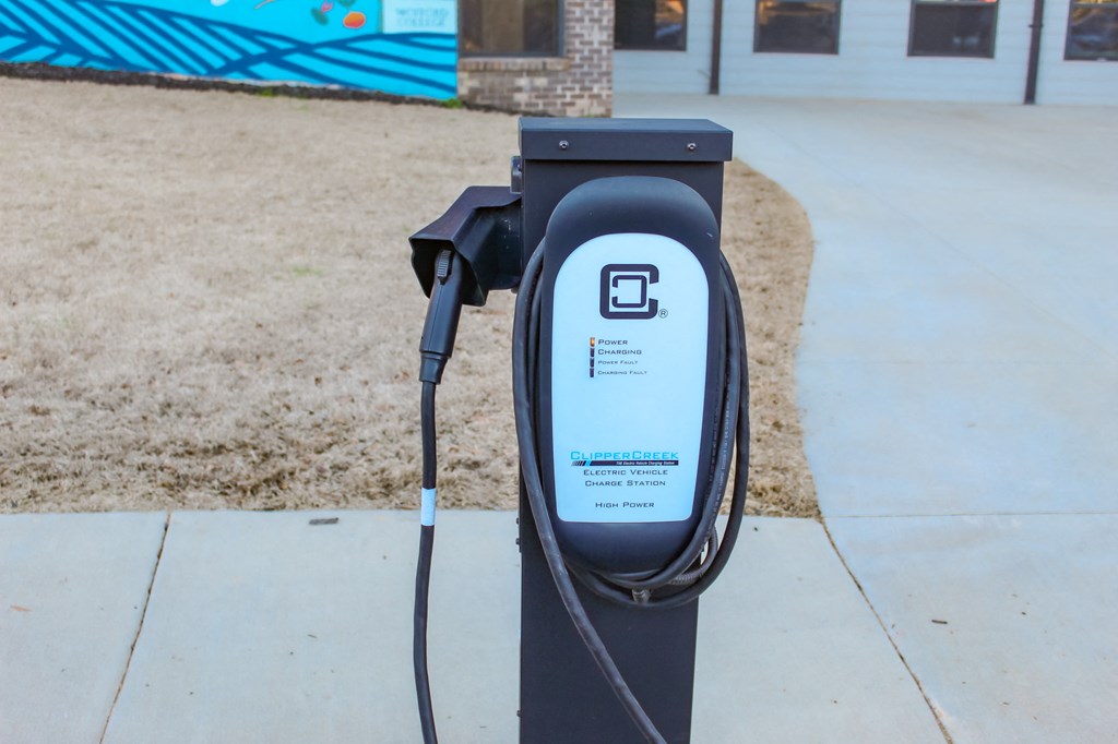 an electric car charger sitting on the side of a sidewalk