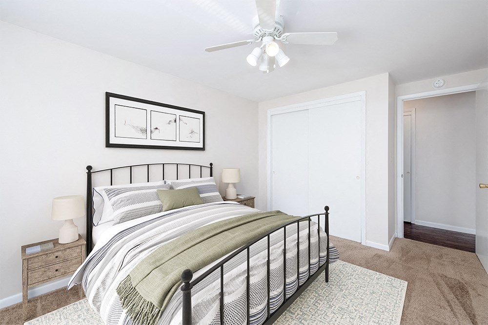 a bedroom with a bed and a ceiling fan