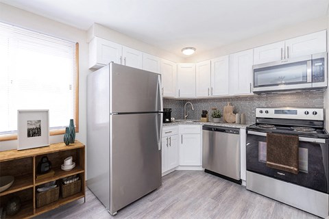 a kitchen with stainless steel appliances and white cabinets