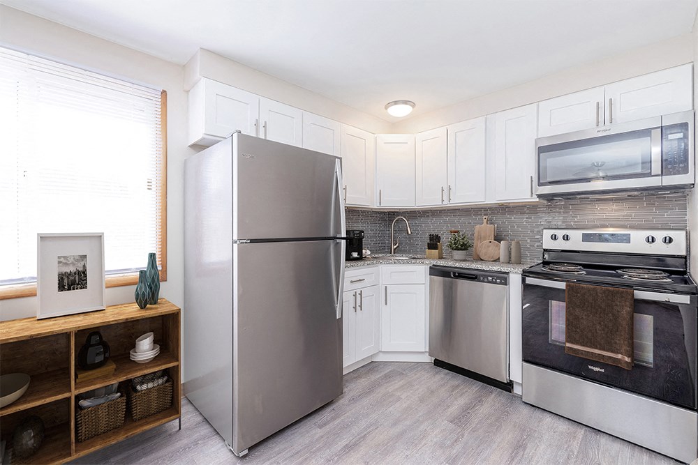 a kitchen with stainless steel appliances and white cabinets