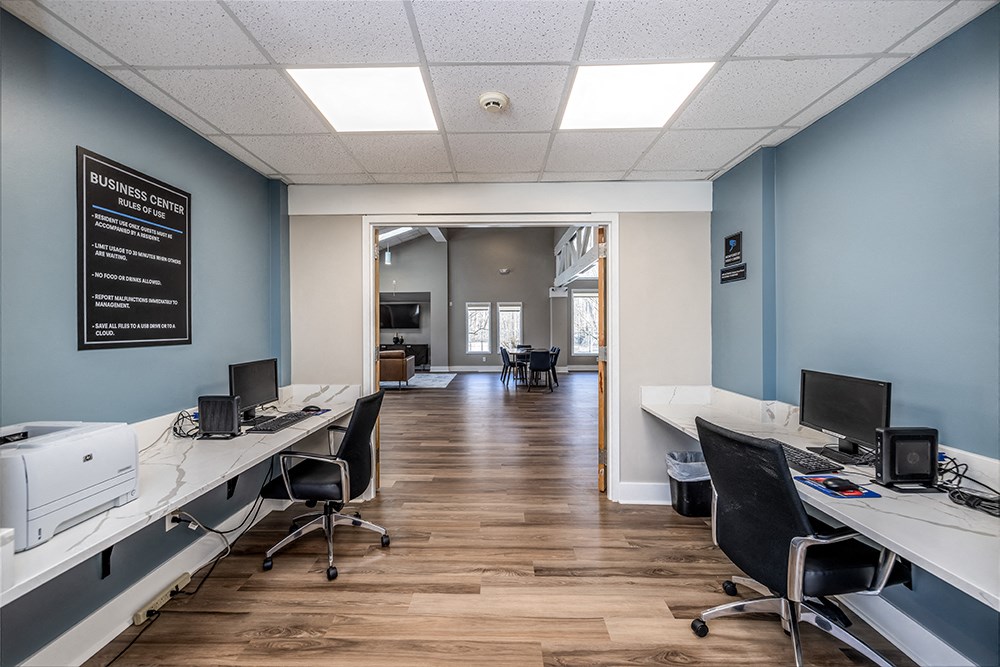 a office with two desks and chairs and a hallway with a door