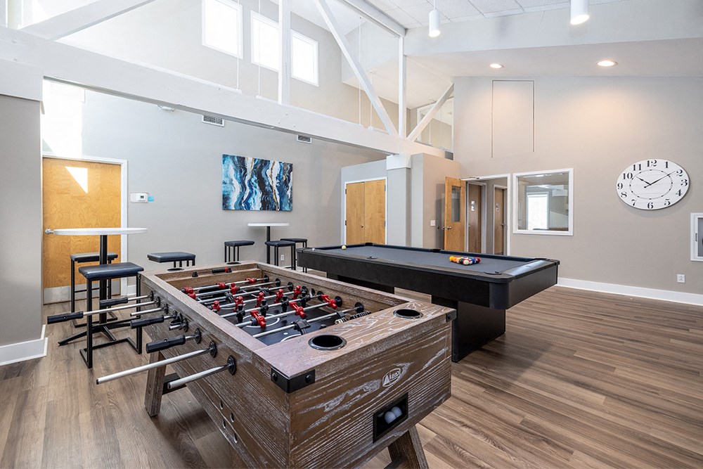 a game room with a foosball table and a pool table
