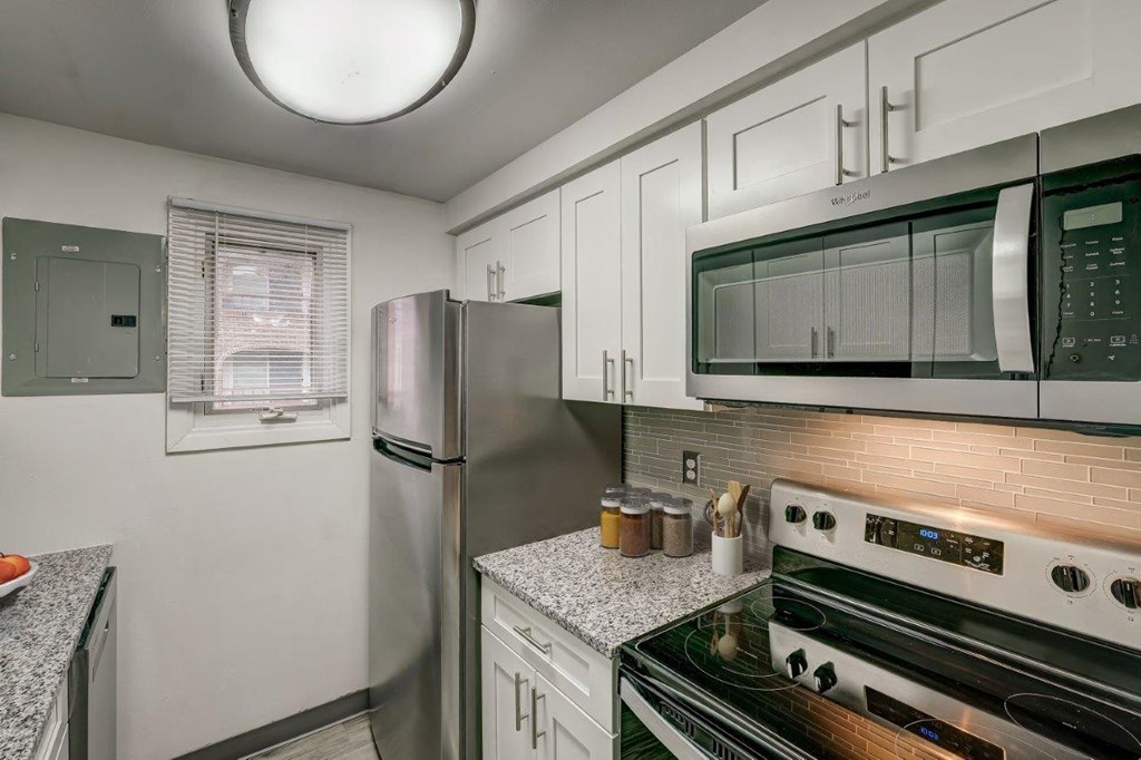 a kitchen with stainless steel appliances and white cabinets
