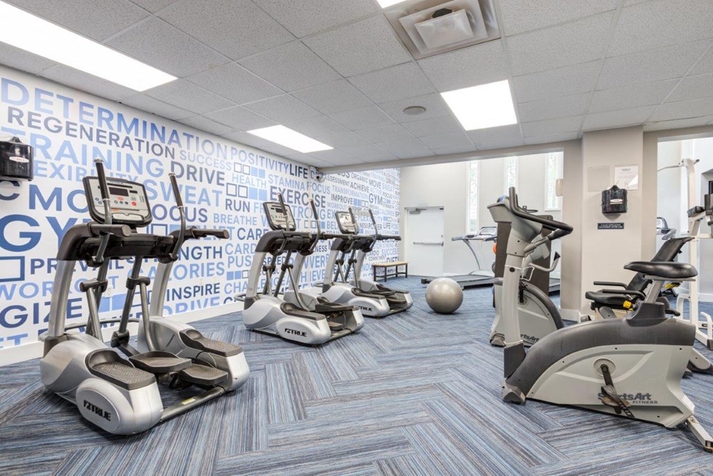 a gym with various exercise bikes and weights on the floor