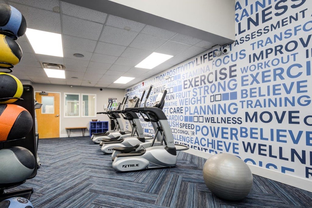 a gym with weights and a wall with words on it