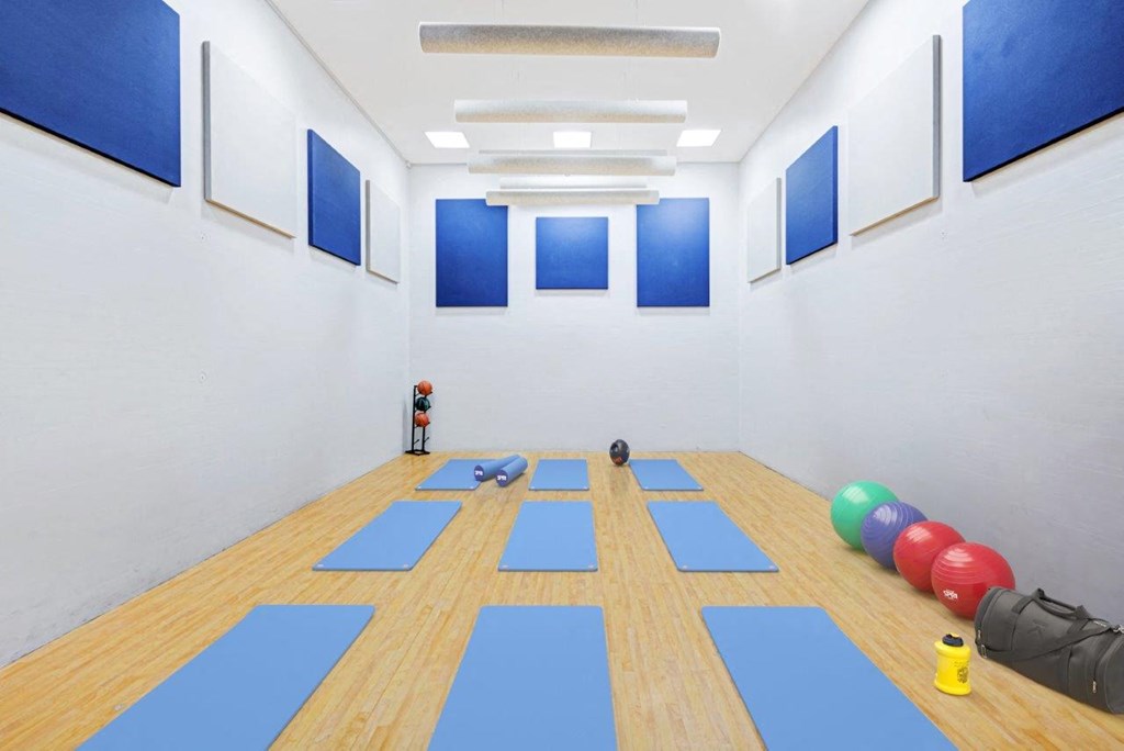 a white yoga room with blue yoga mats on the floor