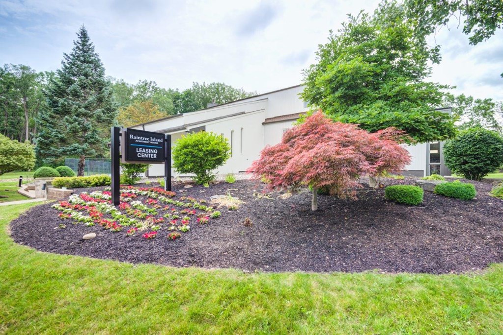 a building with a sign in front of a flower garden