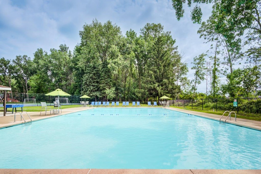 a swimming pool with trees in the background