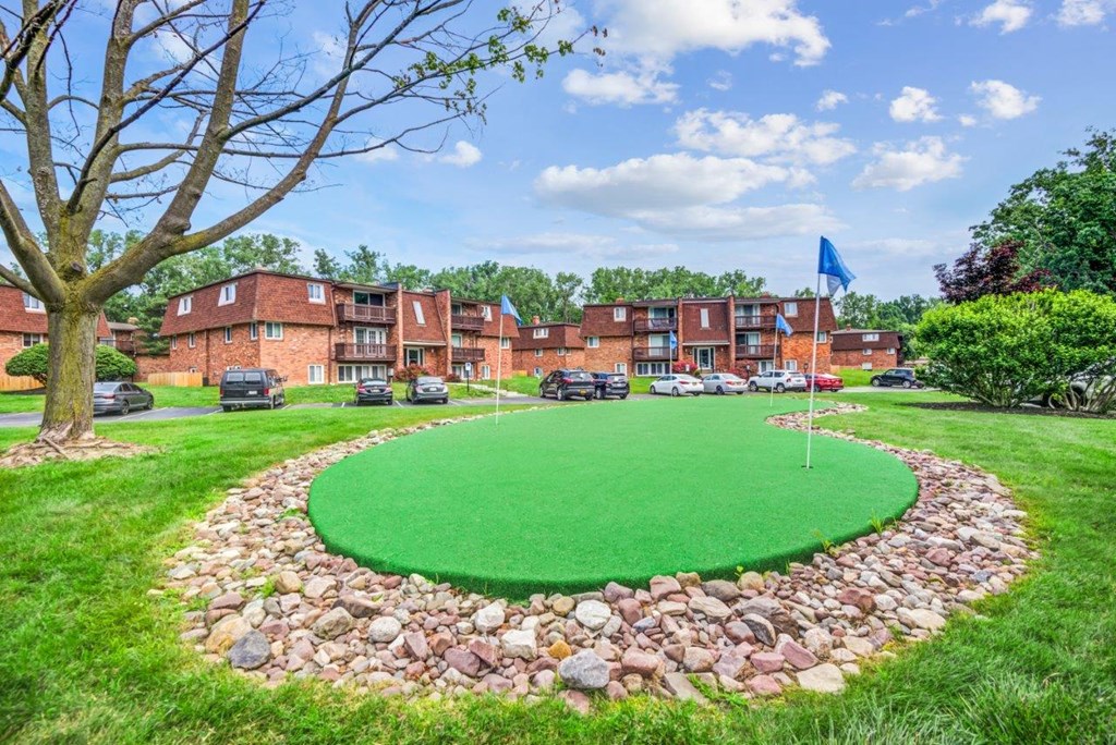 a circle of grass with a flag pole in the middle of it