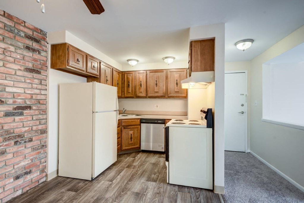a kitchen with a brick wall and white appliances