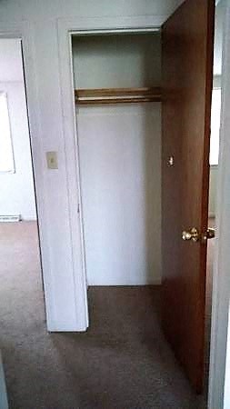 an empty room with an open door and a closet