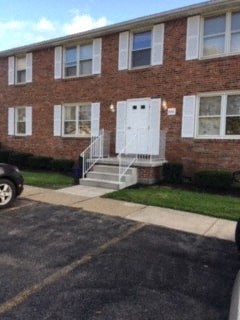 the front of a brick apartment building with a white door