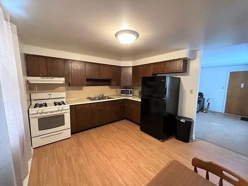 an empty kitchen with a stove and a refrigerator