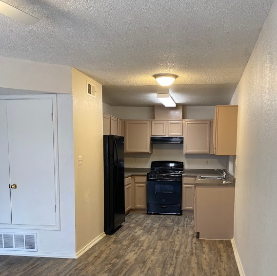 A kitchen with a black refrigerator, stove, and oven.