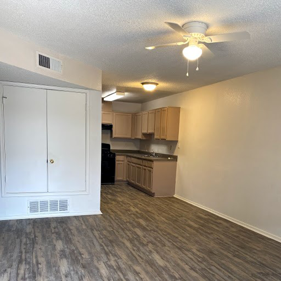 A kitchen with a white door and a ceiling fan.