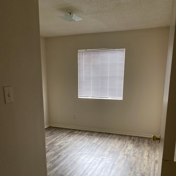 A room with a window covered in blinds and a light on the ceiling.