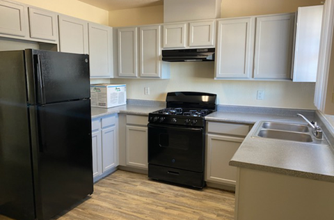 a kitchen with black appliances and white cabinets